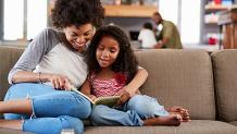 Mom and daughter reading on the couch